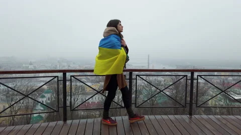 Woman walking at empty observation deck with national flag of Ukraine on shoulde Stock Footage 179606306