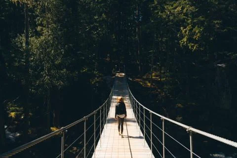 Woman walking on empty path through green forest Stock Photos