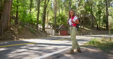 Woman Walking on Forest Road with Backpack Stock Footage 323904859
