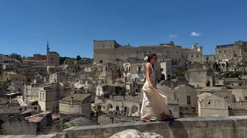 Woman Walking in Front of Sassi di Matera Italy Panorama Stock Footage 336672993