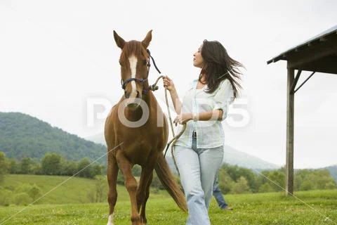 Woman walking with a horse Stock Photos