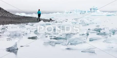 Woman walking over the beach at Jokulsarlon glacier lagoon - Iceland Stock Photos
