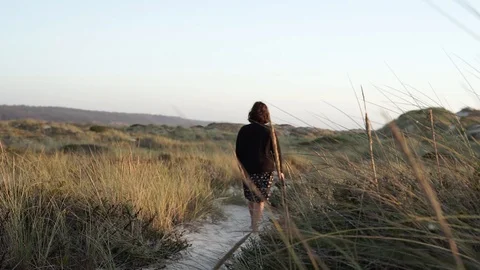 Woman walking in a sandy path surrounded by green and yellow foliage. Stock Footage 116438296