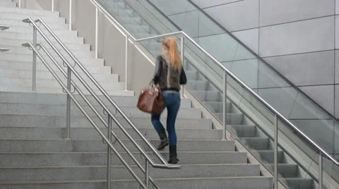 Woman walking up the stairs Stock Footage