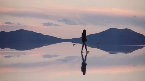 Woman walking on sunset reflection Stock Footage 77401178