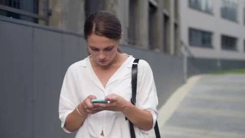 Woman walking, text messaging, thinking and replying on smartphone. Video stock 157578677