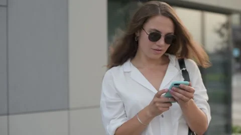 Woman walking, text messaging, thinking and replying on smartphone Stock Footage 157580598