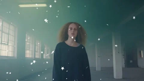 Woman walking toward camera through loft, activating denser star particles for Video stock 332981647