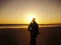 Woman walking towards sunset beach in slow motion Loop Web Footage