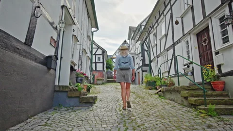 Woman Walking Uphill Between Half-Timbered Houses in Freudenberg Stock Footage 344382005