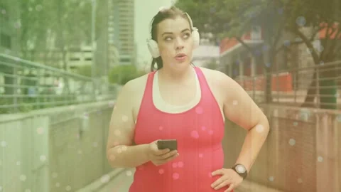 Woman walking urban path, checking phone and watch, looking up for fitness data, Stock Footage 334202689