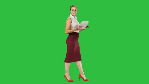Woman walking using digital tablet and talking to camera on a Green Screen Stock Footage 99752436