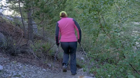 A woman walks along a mountain path. She travels with her family in the park Video stock 94754053