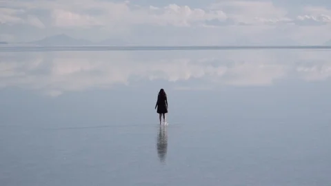 Woman walks barefoot over water Stock Footage