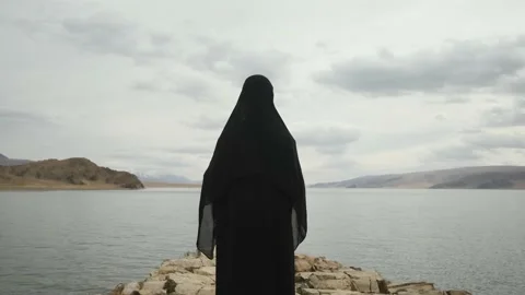 Woman walks to edge of cliff at top of mountain.view from behind Stock Footage 130372653