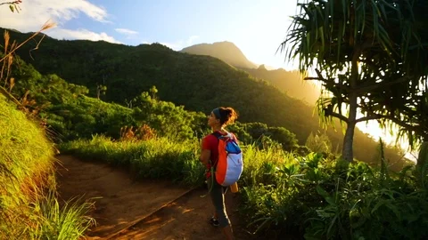 A woman walks through Hawaii jungle on a hike with a backpack. Stock Footage