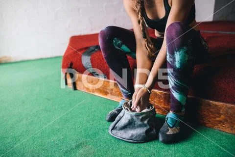 Woman wall climber coating hands with gripping powder Stock Photos