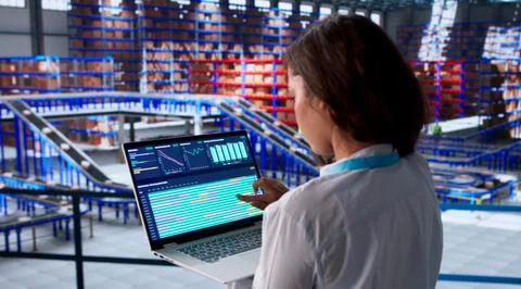 Woman In Warehouse Using Computer To Manage Supply Chain Inventory Data. Fotos Stock