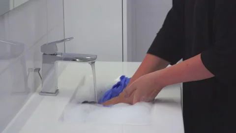 Woman washed blue shirt in sink Stock Footage