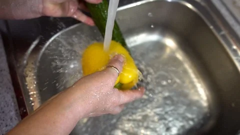 A woman washes vegetables in the kitchen sink. Close up. The view from the top. Stock Footage 123724431