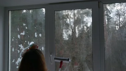 A woman washes a window with a mop. Manual washing of window glass with foam Vídeos de archivo 235930833