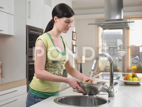 Woman Washing Grapes In Kitchen Sink