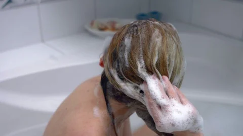 Woman washing hair in bath Stock Footage