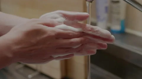 Woman washing hands in steel sink Stock Footage