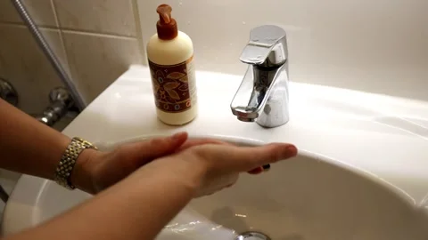 Woman washing her hands with soap under the faucet in the bathroom Stock Footage 326643853