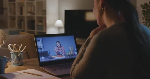 Woman watching cooking tutorials on her laptop Stock Footage 168388834