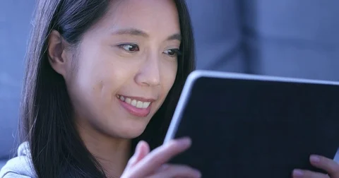 Woman watching drama on tablet computer at home in the evening Stock Footage