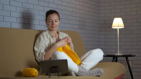 Woman watching online video tutorial and knitting 스톡 동영상 329058113
