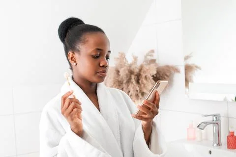 Woman watching tutorial how to use face massager Stock Photos