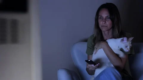 Woman Watching TV while Sitting with Her Cat on Sofa in Living Room at Home. 4K. Stock Footage 149776653