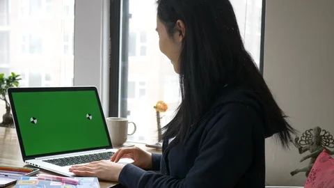 Woman waves to computer screen chroma Stock Footage 128464884