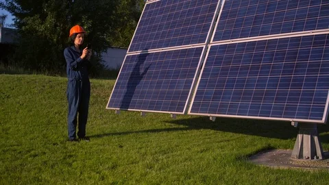 Woman wearing hardhat does a calculation on her smartphone Stock Footage 113455319