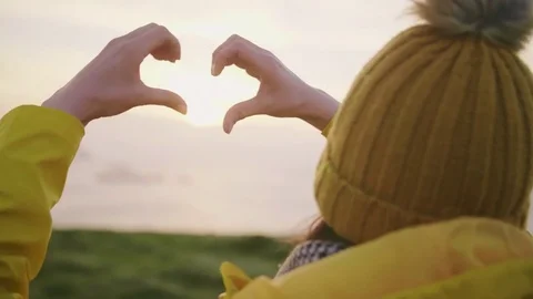 Woman Wearing Hat While Making Heart With Hands Against Sky Stock Footage 79658448