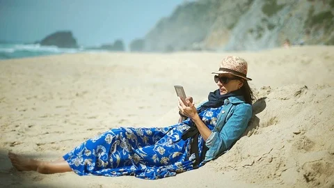 Woman wearing protection from sun and browsing internet on smartphone Stock Footage