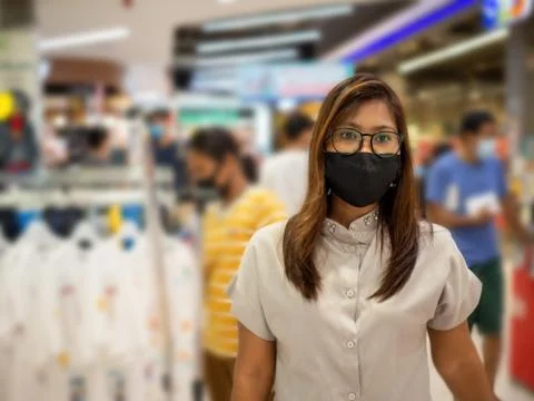 A woman wearing a protective mask While walking in the mall. Stock Photos