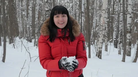 Woman wearing a red jacket throwing snow in the air in winter holidays Stock-Footage 61890617