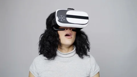 Woman wearing virtual reality goggles looking around gesturing thumb up Stock Footage