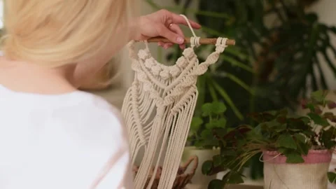 Woman weaving macrame from light threads in a home workshop. Stock Footage 154095692