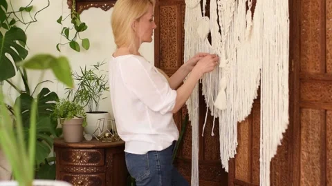 Woman weaving macrame from light threads in a home workshop. Stock Footage 154342663