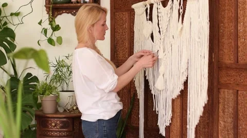 Woman weaving macrame from light threads in a home workshop. Stock Footage 154342666