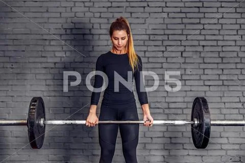 Woman with weight barbell doing deadlift exercise Stock Photos