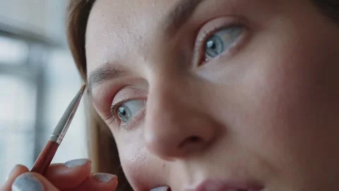A woman while using eyebrow brush for apply color to her eyebrows. Self makeup Vidéo 288261616
