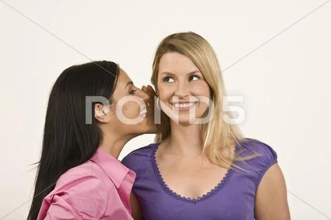 Woman whispering to friend Stock Photos