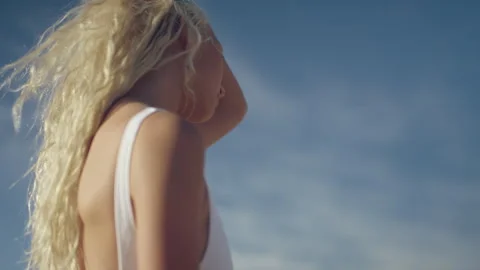 Woman in a white bathing suit pulling her hair back Stock Footage 279855434