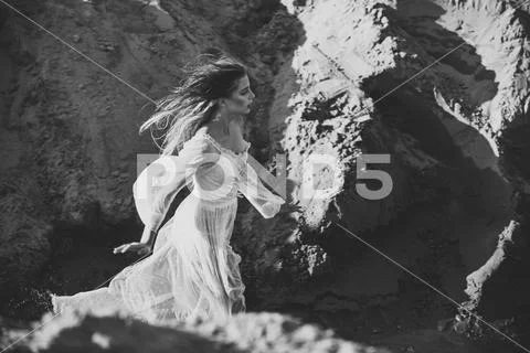 Woman in white dress in canyon on sunny day, fashion Stock Photos