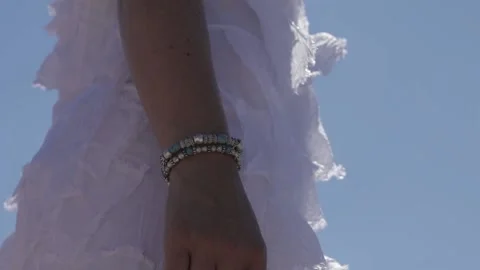 Woman in white dress standing in front of a blue sky Stock Footage